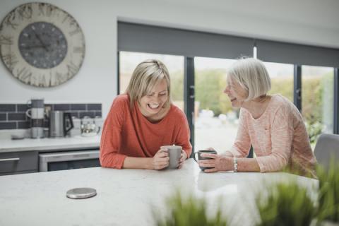 Two women having a conversation in a kitchen