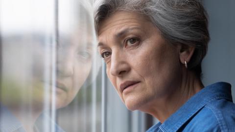 Woman with depression looks out a window